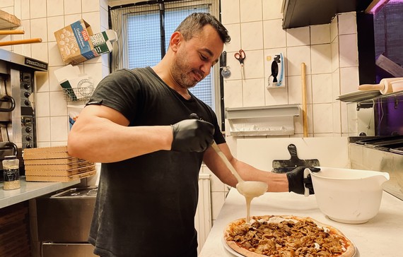 Anwar på Sverkers pizzeria tillagar en pizza.