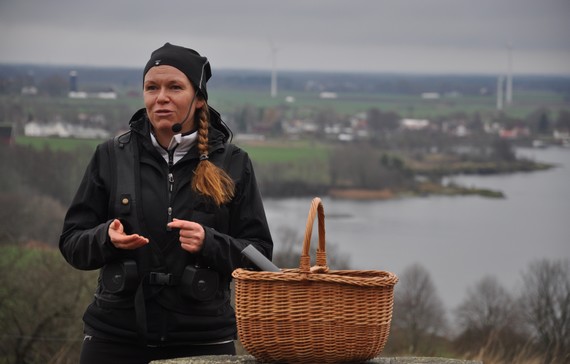 En lokal guide som står och pratar framför en utsiktsplats över Hästholmen.