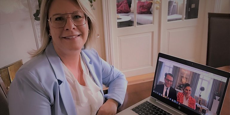 Annicki Oscarsson, kommunstyrelsens ordförande sitter med datorn framför sig där kronprinsessparet finns med i bild.
