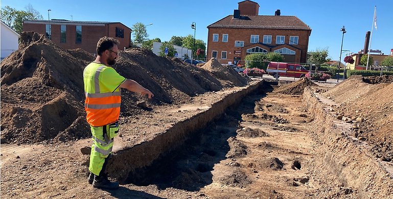 Arkeolog Mattias Johansson framför öppet schakt på "postenparkeringen"